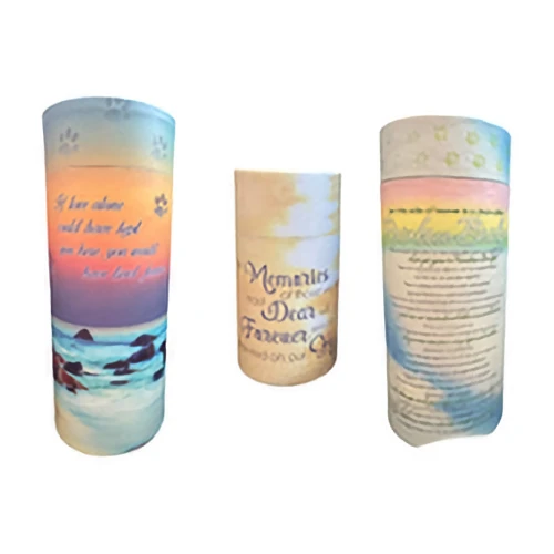 Three decorative cylindrical scatter tubes for pet ashes are shown. They feature paw prints, sunset landscapes, and comforting quotes about pet remembrance.